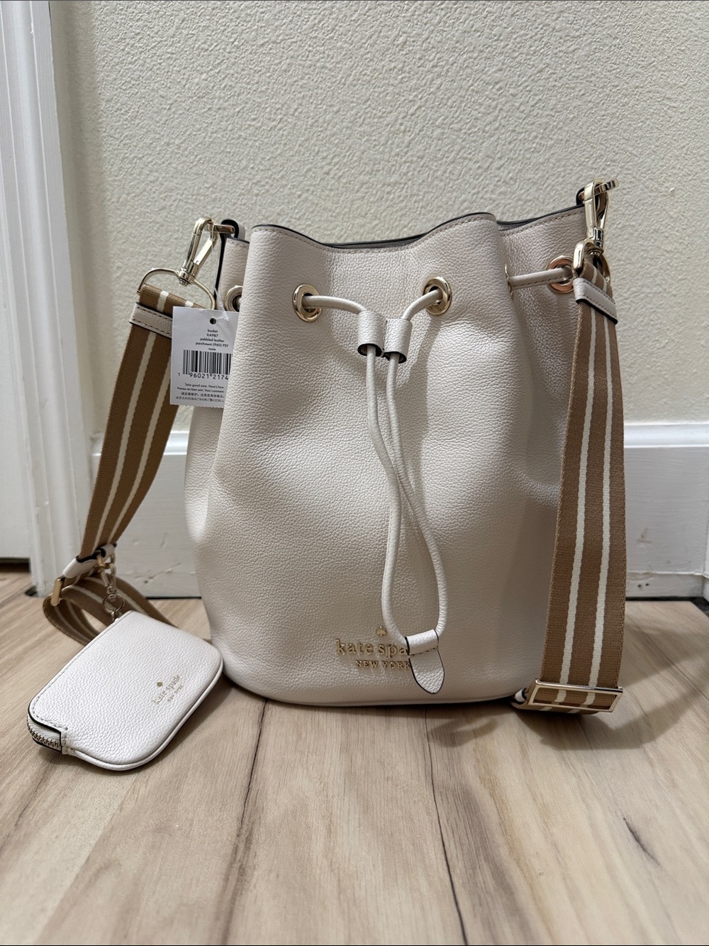 kate spade cream pebble leather drawstring bucket bag with striped tan strap